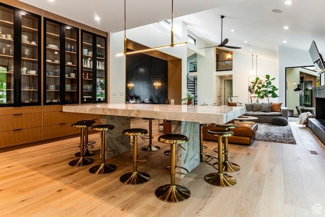 4155 S Parkview Dr, Salt Lake City, UT 84124 - bar featuring light wood-type flooring, recessed lighting, a fireplace with raised hearth, ceiling fan, and high vaulted ceiling