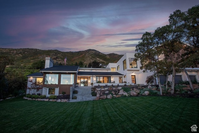 4155 S Parkview Dr, Salt Lake City, UT 84124 - back of house at dusk with a yard, a mountain view, and a chimney