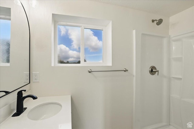 full bath with a shower and vanity