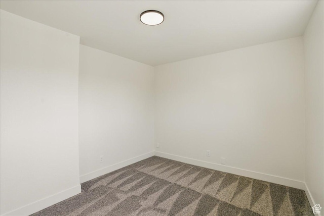 carpeted spare room featuring baseboards