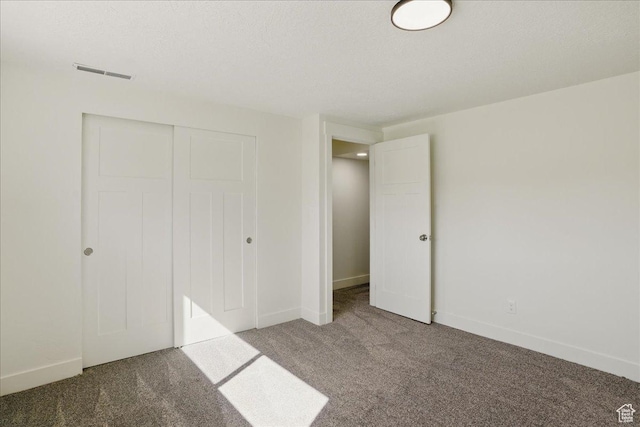 unfurnished bedroom with visible vents, baseboards, carpet flooring, and a closet