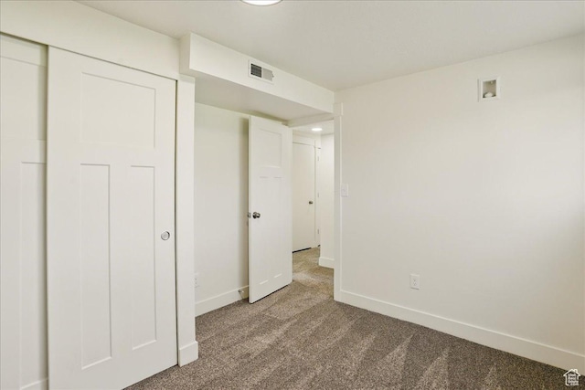 unfurnished bedroom with carpet, visible vents, and baseboards