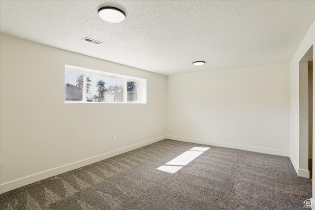 carpeted empty room with a textured ceiling, baseboards, and visible vents