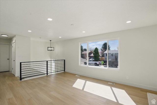 empty room featuring baseboards, recessed lighting, and wood finished floors