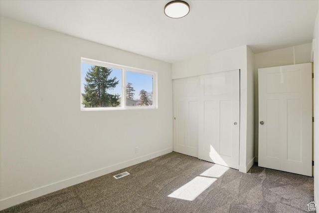 unfurnished bedroom featuring visible vents, a closet, baseboards, and carpet floors