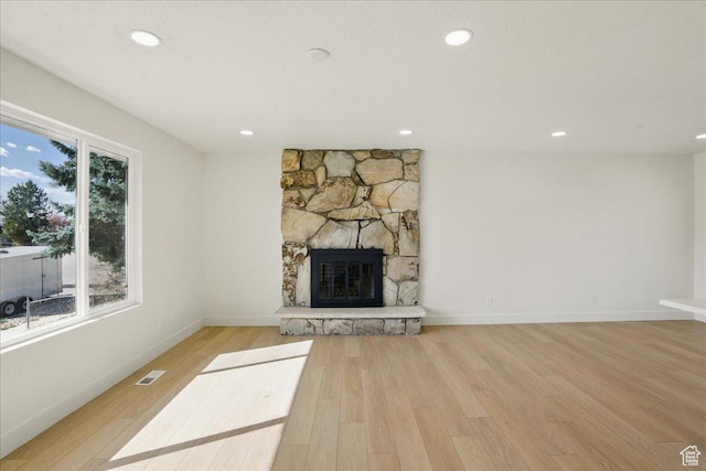 unfurnished living room featuring a fireplace, visible vents, recessed lighting, wood finished floors, and baseboards