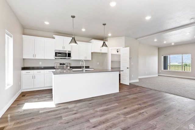 632 E 730 N, Hyrum, UT 84319 - kitchen with baseboards, dark countertops, an island with sink, and stainless steel appliances