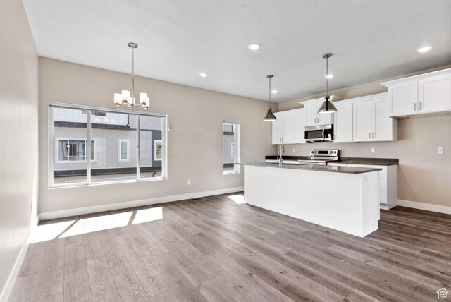 632 E 730 N, Hyrum, UT 84319 - kitchen with appliances with stainless steel finishes, baseboards, dark wood-style floors, and a notable chandelier