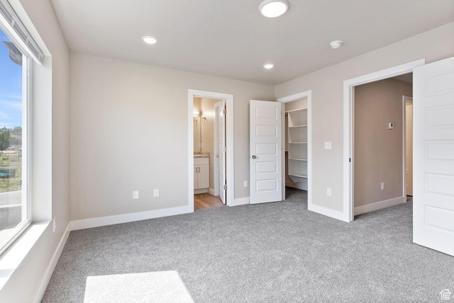 632 E 730 N, Hyrum, UT 84319 - unfurnished bedroom with baseboards, a walk in closet, and light carpet
