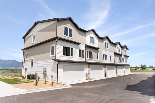 632 E 730 N, Hyrum, UT 84319 - view of front of property with a garage, central AC unit, stucco siding, and a mountain view