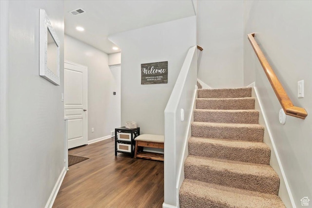 stairway featuring visible vents, baseboards, recessed lighting, and wood finished floors