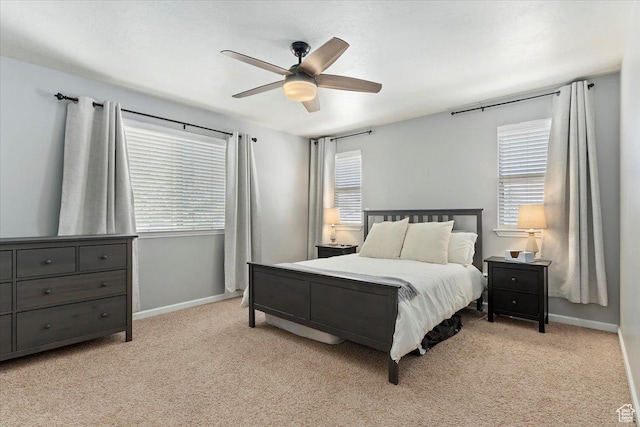 bedroom featuring light carpet, baseboards, and multiple windows