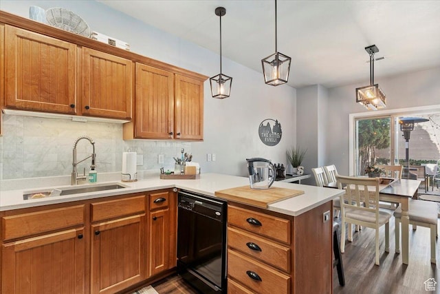 kitchen with tasteful backsplash, black dishwasher, a sink, light countertops, and a peninsula