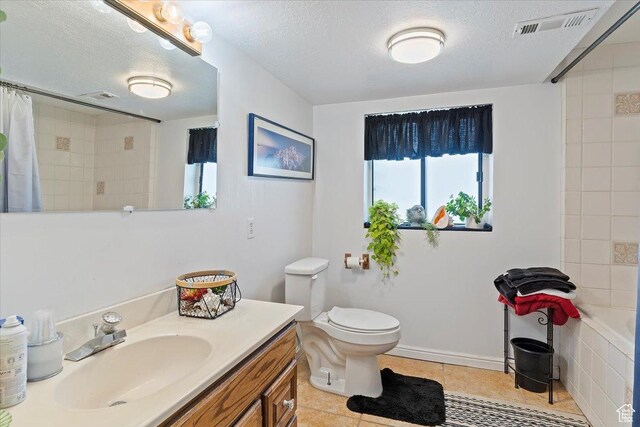 full bath featuring a textured ceiling, tiled shower, vanity, visible vents, and tile patterned floors