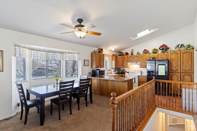 dining space featuring light carpet, vaulted ceiling, and a ceiling fan