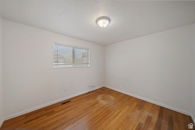 empty room featuring light wood-style flooring, baseboards, and visible vents