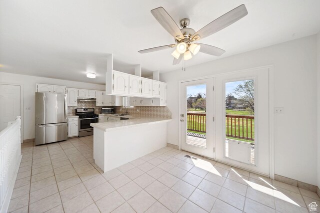 kitchen with a sink, light countertops, appliances with stainless steel finishes, a peninsula, and under cabinet range hood