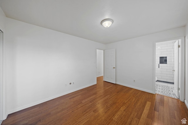 spare room featuring baseboards and wood finished floors