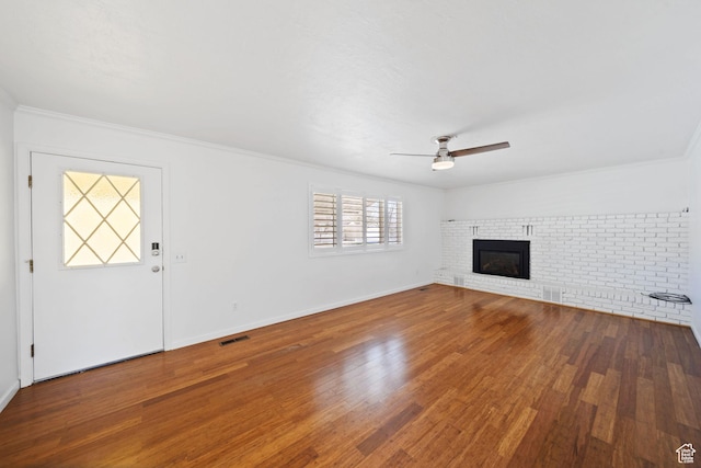 unfurnished living room with visible vents, ceiling fan, crown molding, and wood finished floors