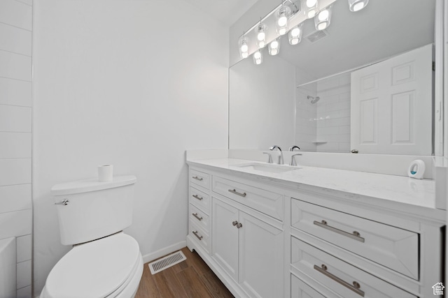 full bath featuring vanity, walk in shower, toilet, visible vents, and wood finished floors