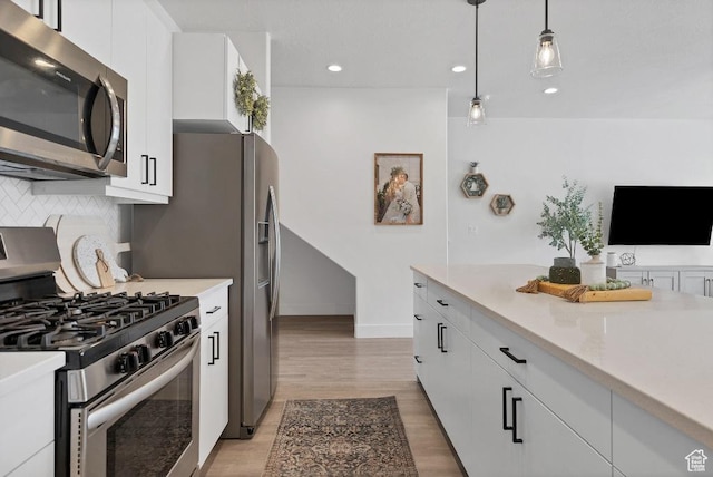 kitchen with light countertops, decorative backsplash, white cabinetry, and appliances with stainless steel finishes