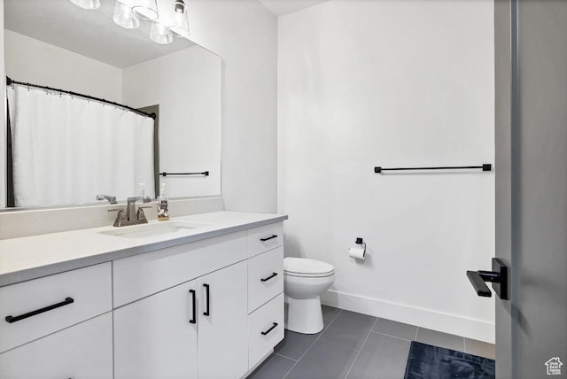 bathroom featuring tile patterned floors, vanity, baseboards, and toilet