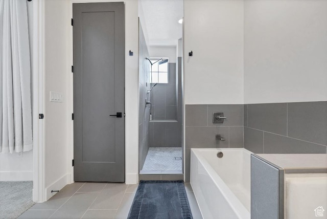 bathroom with a tile shower, a garden tub, baseboards, and tile patterned flooring