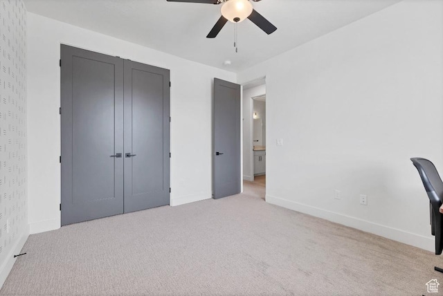 interior space featuring light carpet, ceiling fan, and baseboards