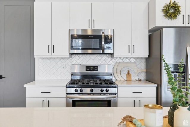 kitchen featuring tasteful backsplash, light countertops, white cabinetry, and stainless steel appliances