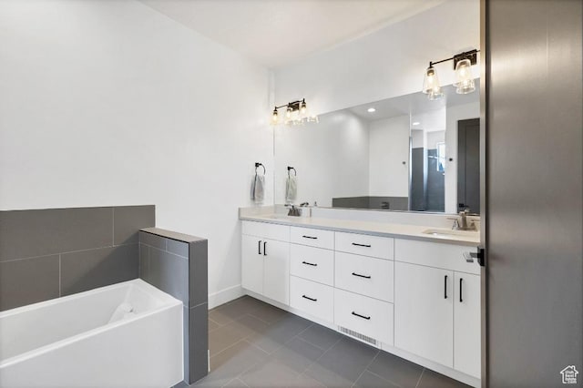 bathroom with tile patterned flooring, double vanity, a bath, and a sink
