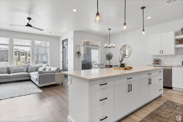 kitchen with plenty of natural light, dishwasher, ceiling fan with notable chandelier, and open shelves