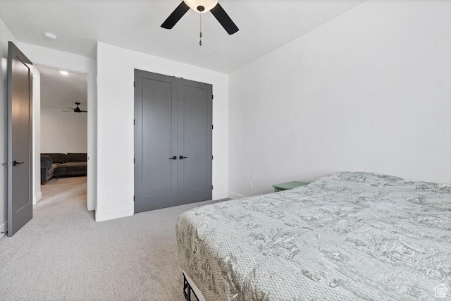 carpeted bedroom with baseboards, a closet, and a ceiling fan