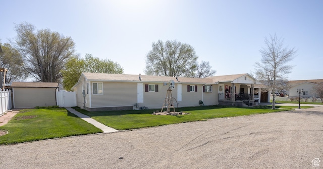 145 S 100 E, Redmond, UT 84652 - ranch-style home featuring a storage shed, a porch, fence, an outbuilding, and a front lawn