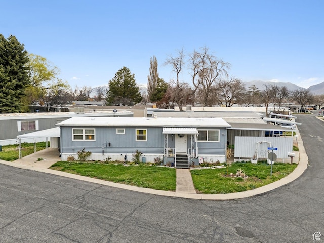 5100 S 1050 W Unit H138, Riverdale, UT 84405 - view of front facade with a carport, a mountain view, and a front lawn