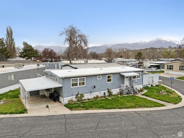 5100 S 1050 W Unit H138, Riverdale, UT 84405 - view of front of home featuring an attached carport, a front yard, driveway, and a mountain view
