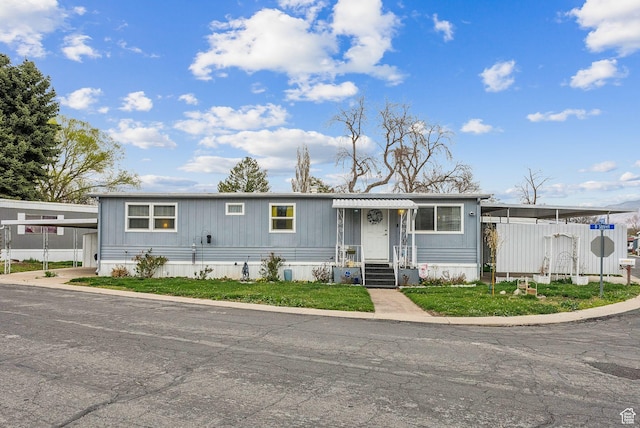 view of front of property with a carport and fence