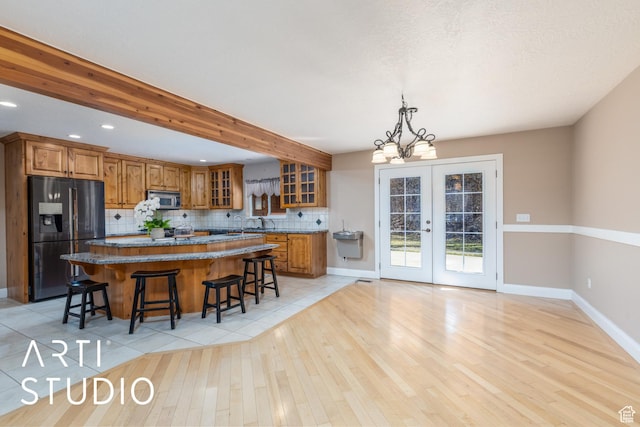260 S 10450 E, Huntsville, UT 84317 - kitchen with brown cabinets, stainless steel microwave, a kitchen island, and black fridge with ice dispenser