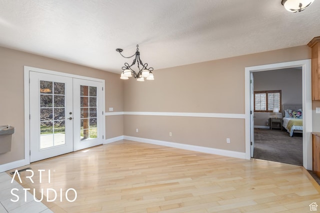 260 S 10450 E, Huntsville, UT 84317 - unfurnished dining area featuring french doors, baseboards, light wood-type flooring, and a textured ceiling