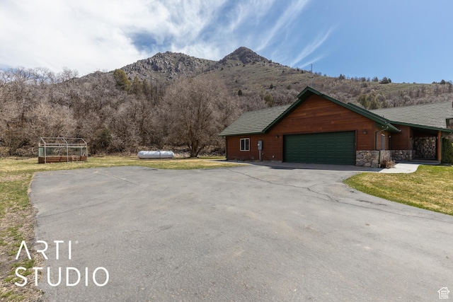 260 S 10450 E, Huntsville, UT 84317 - exterior space featuring a front yard, a mountain view, an attached garage, stone siding, and driveway