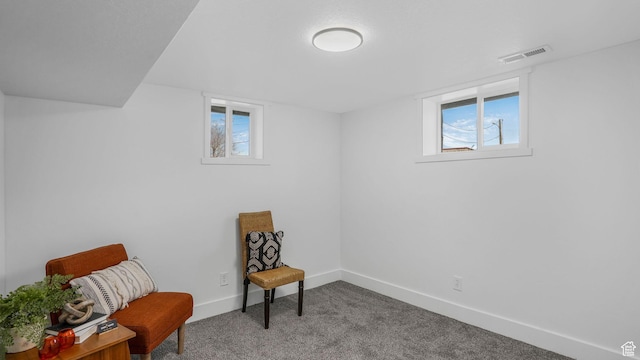 living area with a wealth of natural light, carpet flooring, visible vents, and baseboards