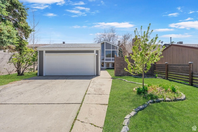 mid-century modern home featuring a garage, fence, and a front yard