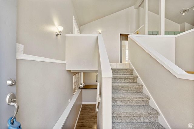 stairs with baseboards, wood finished floors, and lofted ceiling