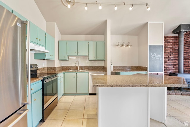 kitchen with a kitchen island, under cabinet range hood, a sink, light tile patterned floors, and stainless steel appliances