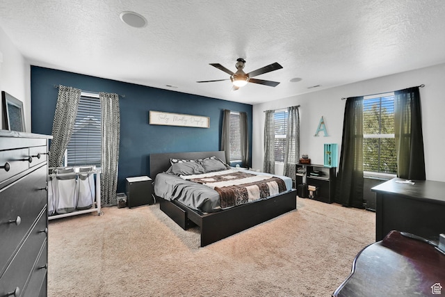 bedroom with a textured ceiling, ceiling fan, and carpet