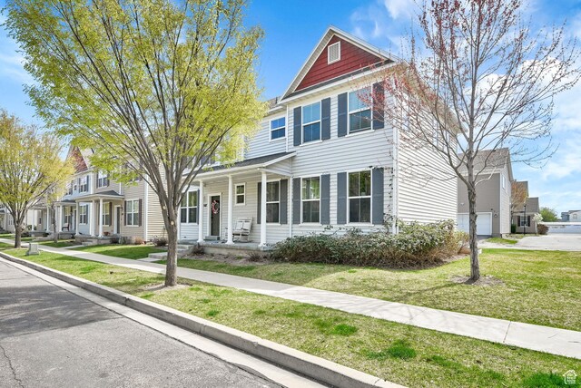 view of front facade with a front yard, a porch, and a garage