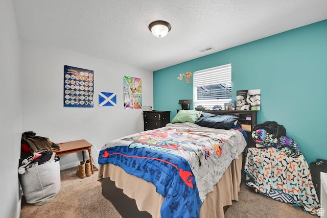 carpeted bedroom featuring a textured ceiling and visible vents