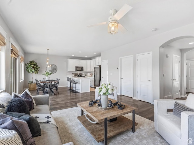 14939 S Winged Bluff Ln, Draper, UT 84020 - living room with arched walkways, light wood-type flooring, ceiling fan, baseboards, and recessed lighting