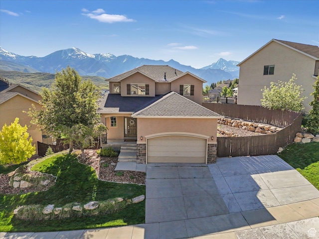 14939 S Winged Bluff Ln, Draper, UT 84020 - view of front of house with stucco siding, a mountain view, a garage, a shingled roof, and driveway