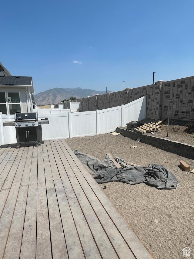exterior space featuring a deck with mountain view and a fenced backyard