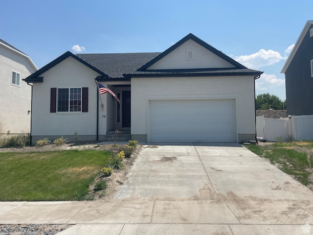 single story home with concrete driveway, stucco siding, a front lawn, a garage, and fence